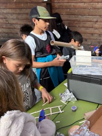 Lower school students using the Field Station solar and battery power for hot glue guns.